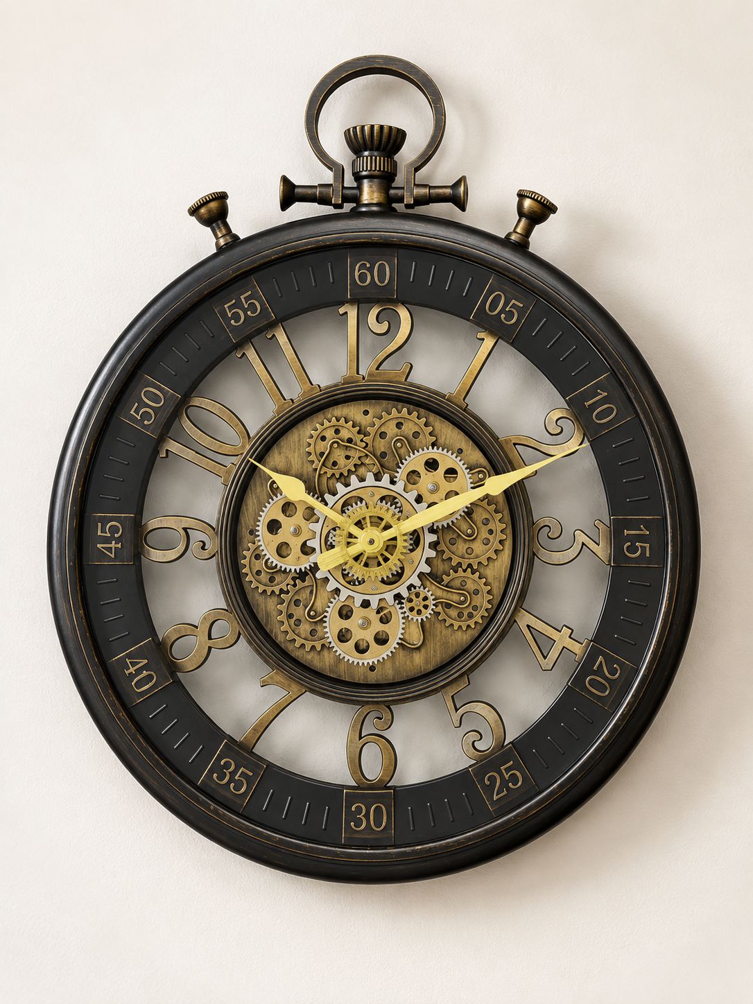 A round steampunk-style wall clock with a black outer frame, gold-tone numerals and hands, and a visible internal gear mechanism in the center, photographed against a plain light background.