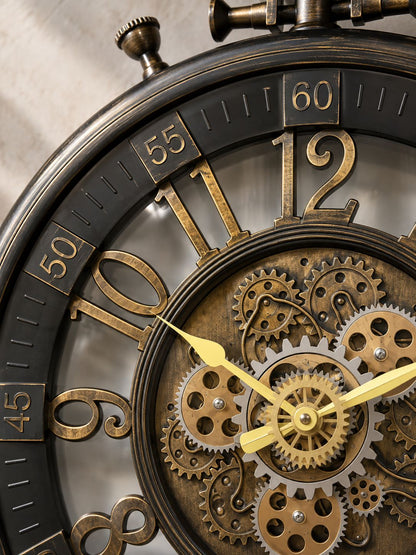 Close-up of a vintage-style mechanical pocket watch with exposed brass gears, gold-toned numerals, and dark metal casing on a neutral background.