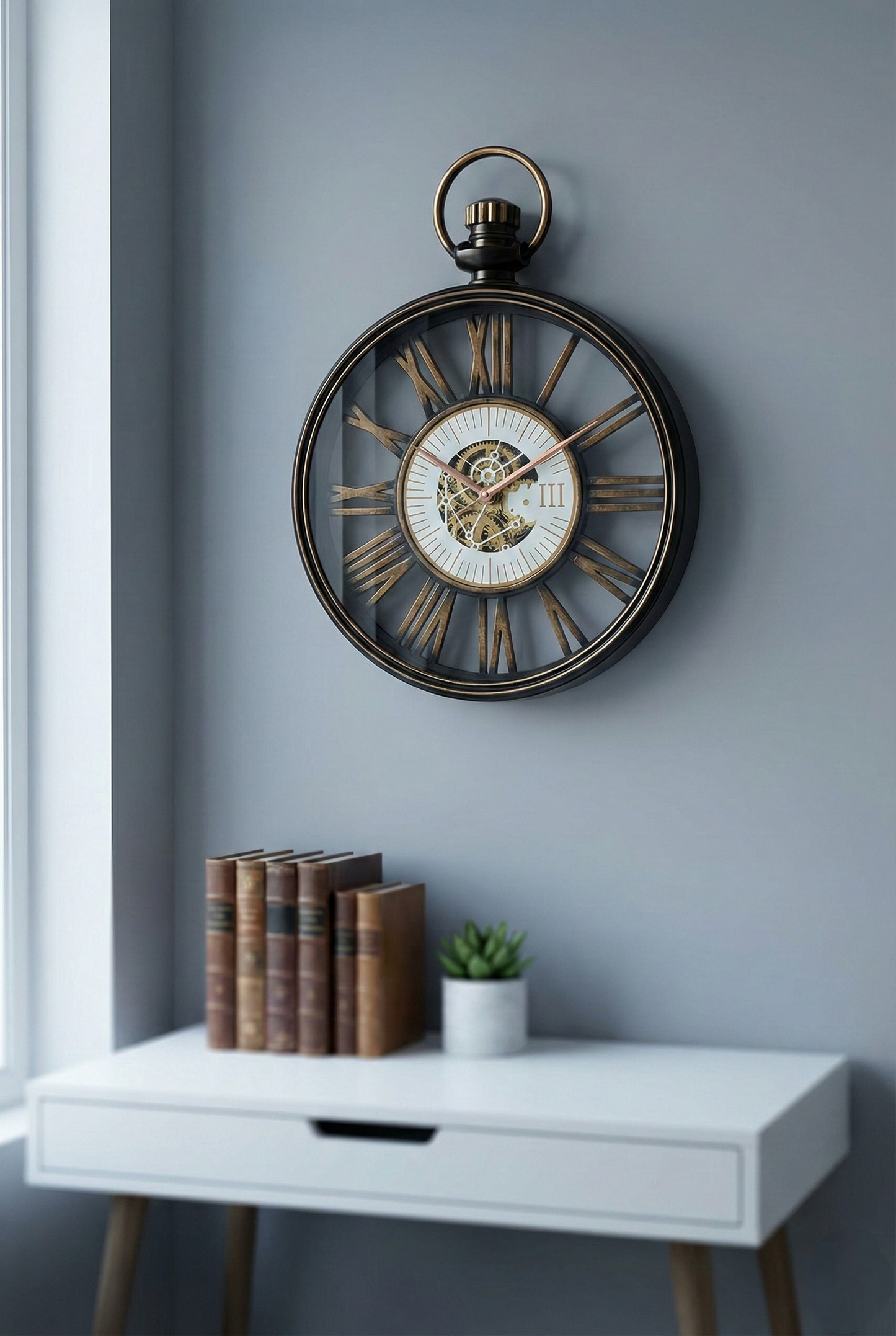 Decorative wall clock on a gray wall above a white desk with books and a plant.