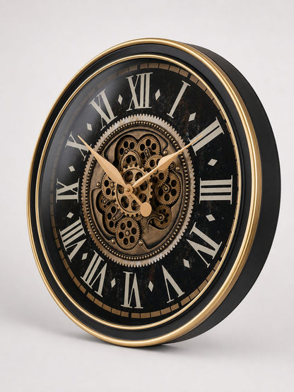 Decorative wall clock with black face, gold rim, and Roman numeral markers on a white background