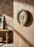 Decorative wall clock with gear design on a textured beige wall
