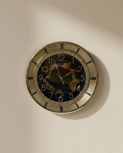 Decorative wall clock with gold frame and black face on a beige wall.
