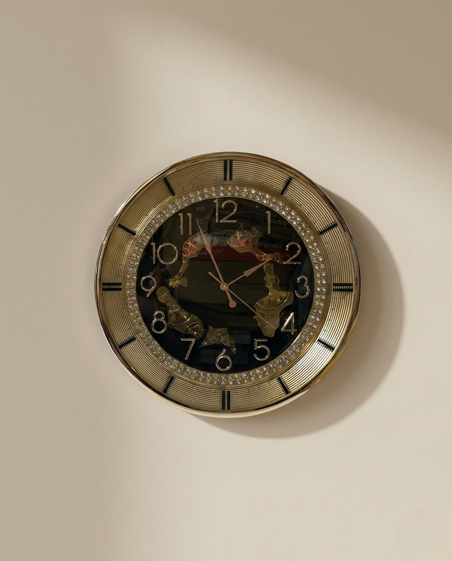 Decorative wall clock with gold frame and black face on a beige wall.