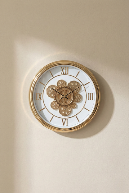 Decorative wall clock with gold frame and white face on a beige wall
