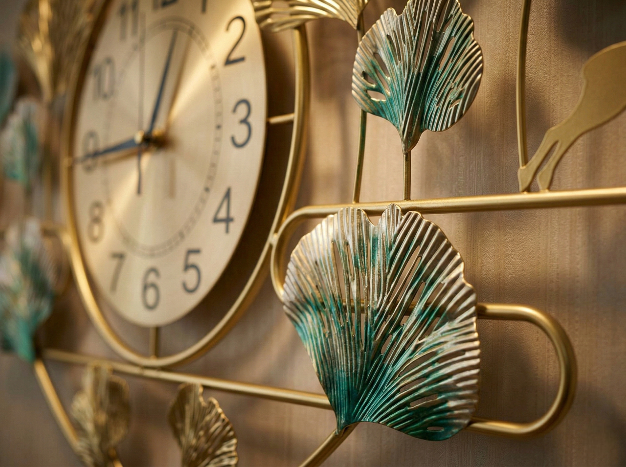 Decorative wall clock with leaf designs on a metallic surface