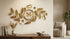 Gold floral wall clock mounted above a wooden console table in a sunlit elegant living room.