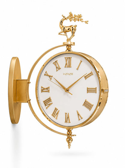 Gold wall clock with a white dial, Roman numerals, a deer finial, and a circular side mount, shown on a white background.