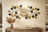 Large gold and black metal floral wall clock with blue jewel accents on living room wall
