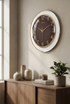 Wall clock on a wall above a wooden console table with decorative items.