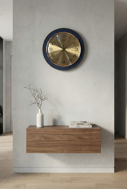 Wall clock with blue frame and gold face on a white wall above a wooden console table.