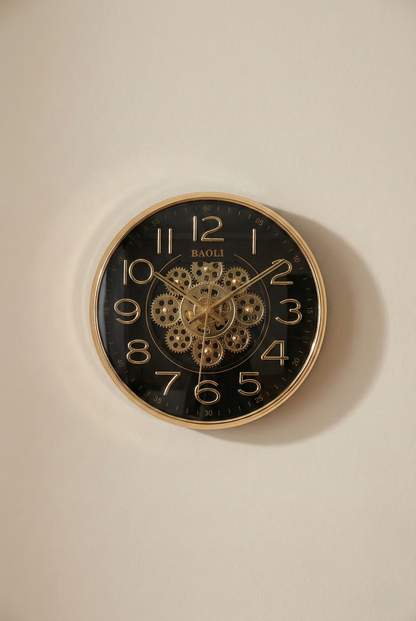 Wall clock with gold casing and black face on a beige wall